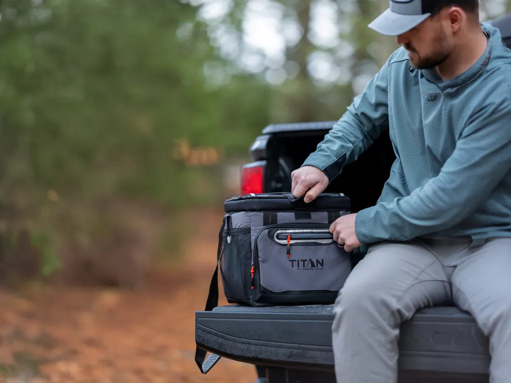 Man sitting on the flatbed of a truck reaching into a Titan Cooler