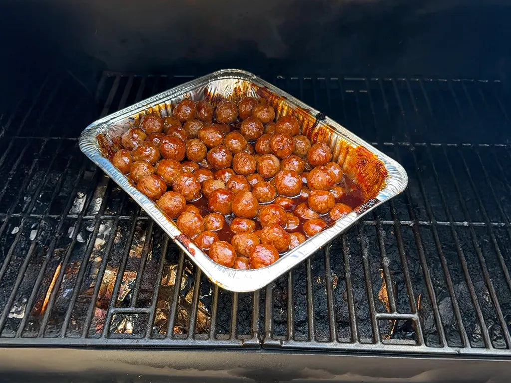 Sweet & Spicy Meatballs in a foil tray on the grill
