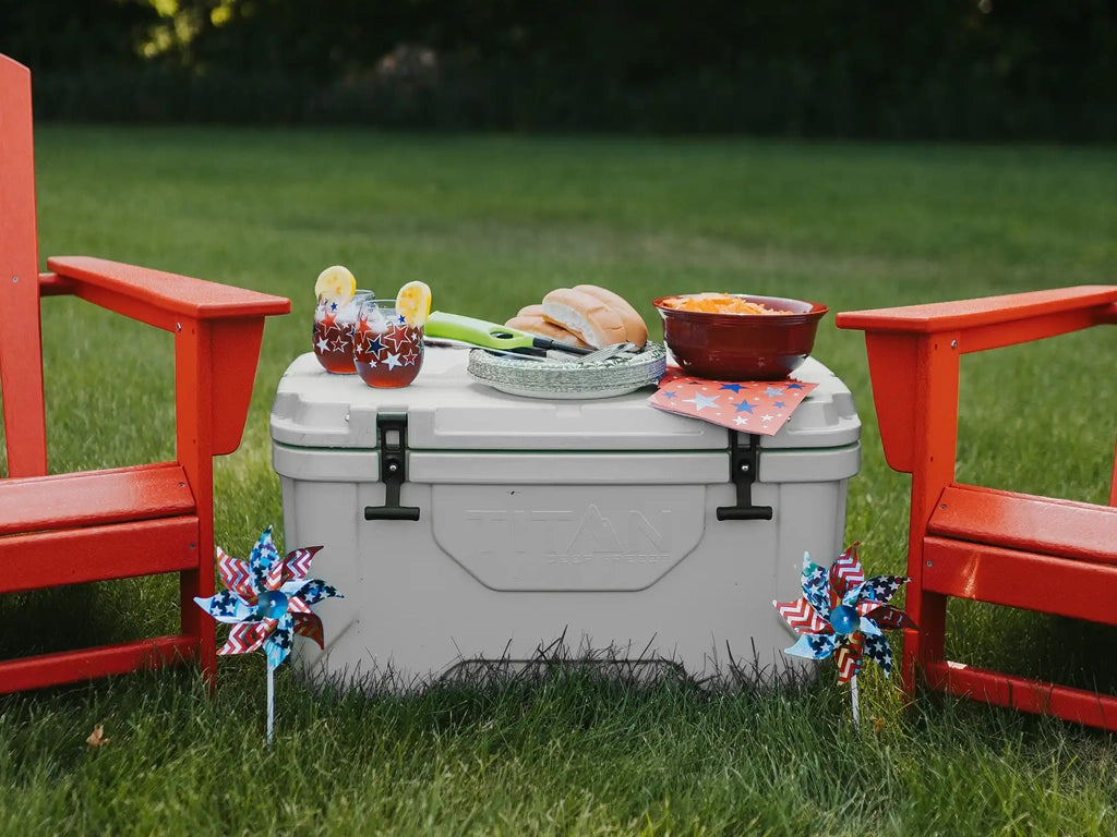 Food and drinks on top of a Titan 55Q Hard Cooler outside during a Memorial Day party