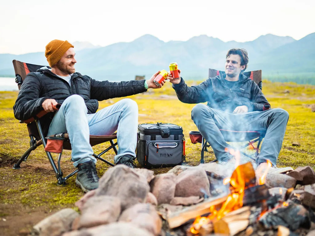 Two guys sitting by a campfire