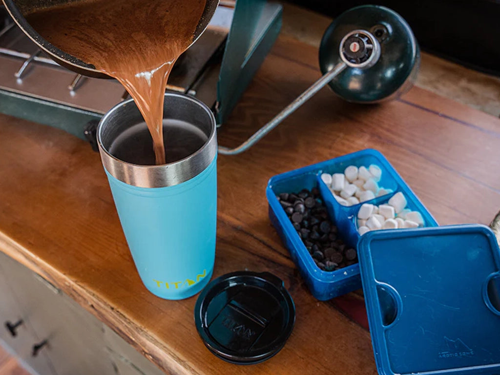 Saucepan of creamy homemade hot chocolate being poured into a Titan 20 Oz. Stainless Steel Tumbler 