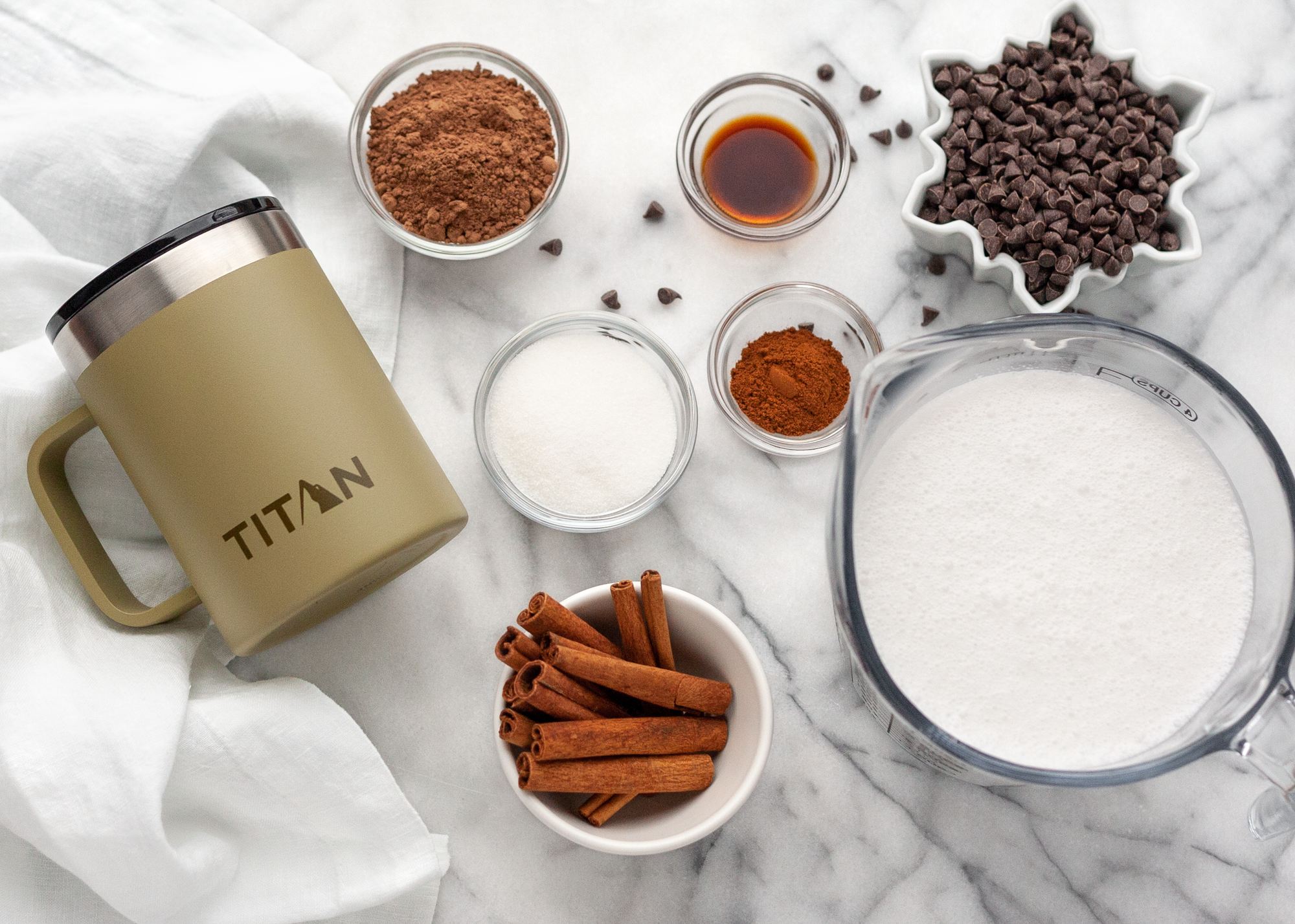 Ingredients to make homemade hot chocolate next to a stainless steel mug