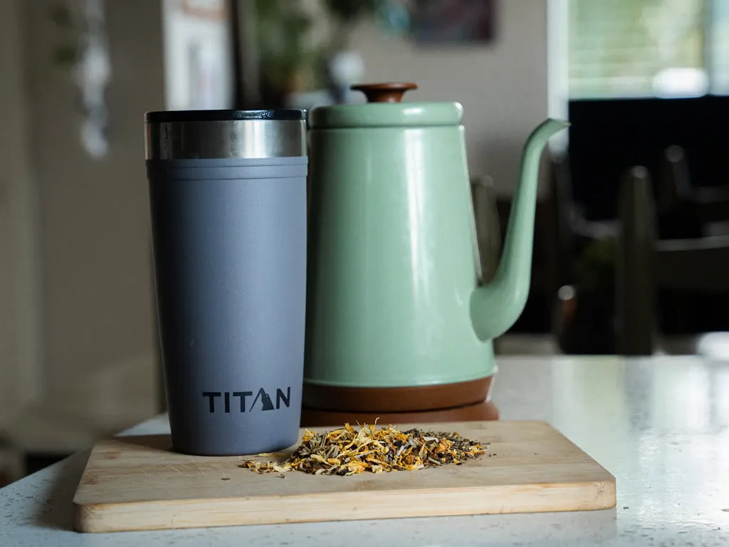 Titan 20 oz Tumbler next to loose leaf and a kettle on a kitchen counter