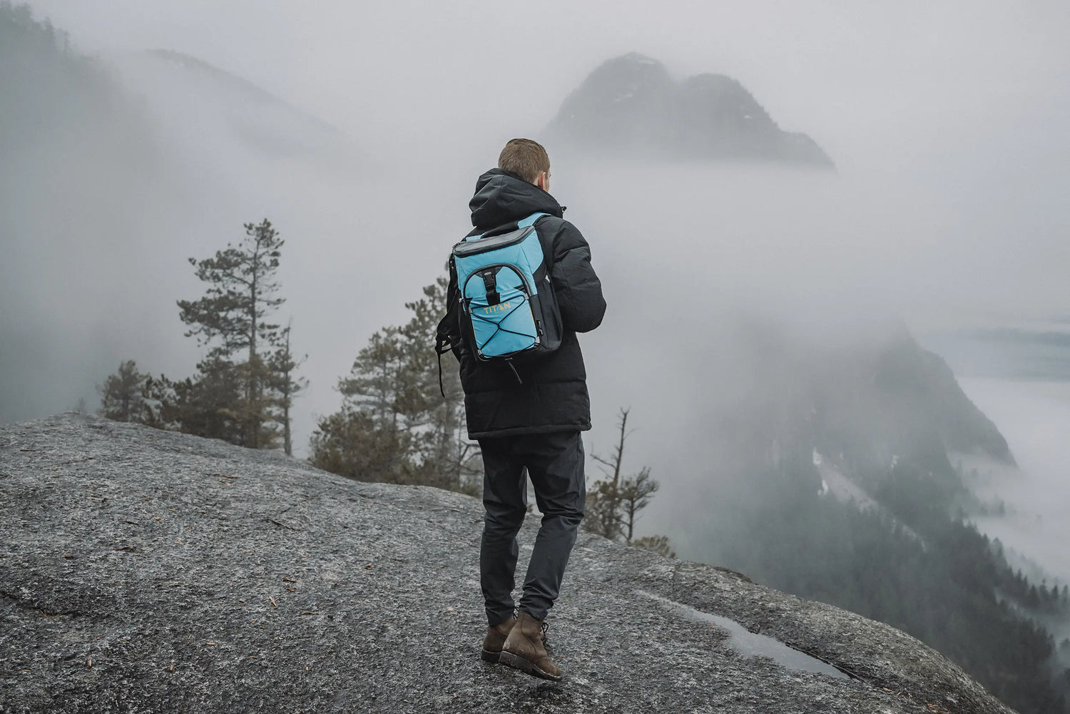 Man wearing a Titan Backpack Cooler while on a mountain