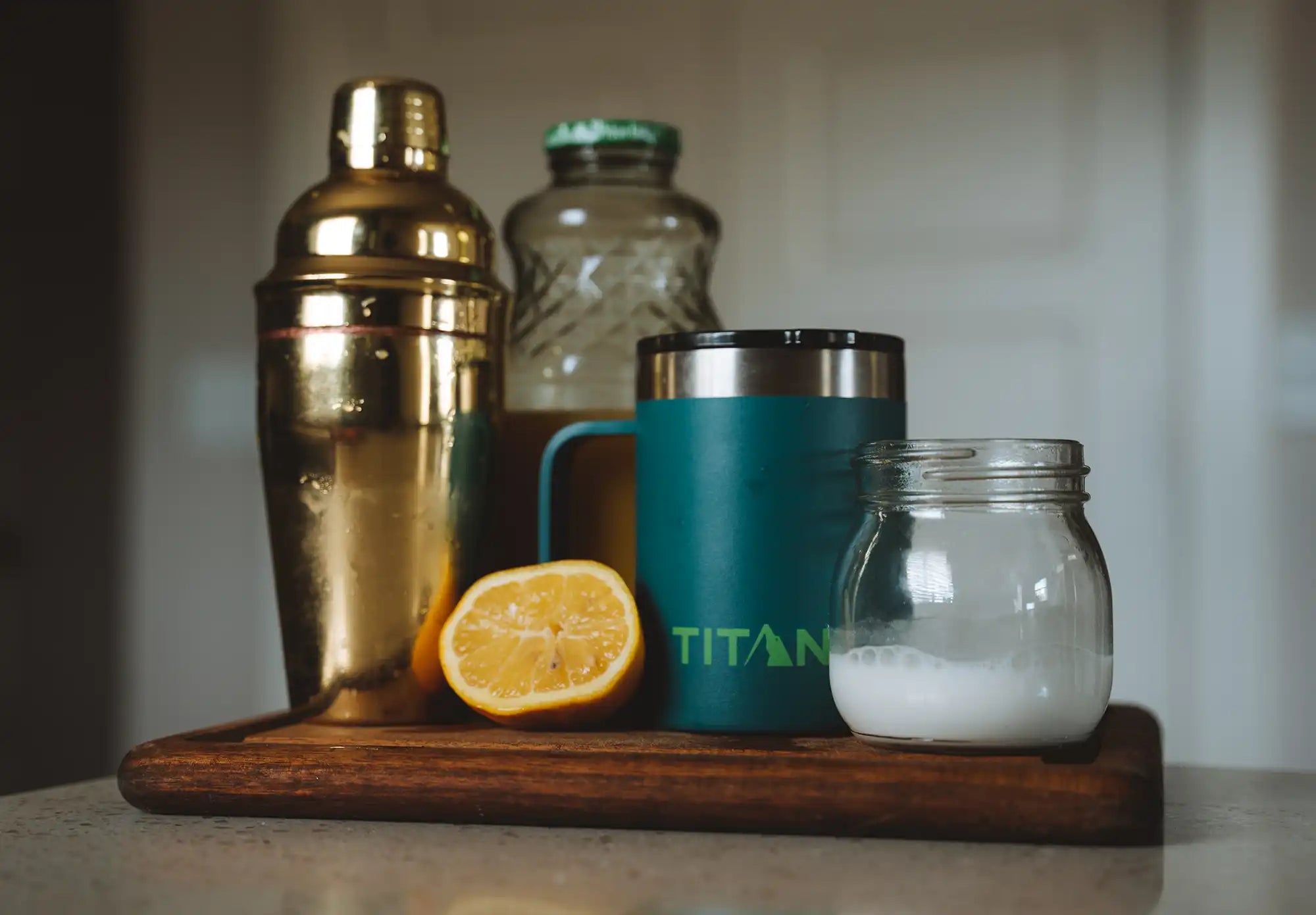 Cocktail shaker next to a Titan Mug and other ingredients.