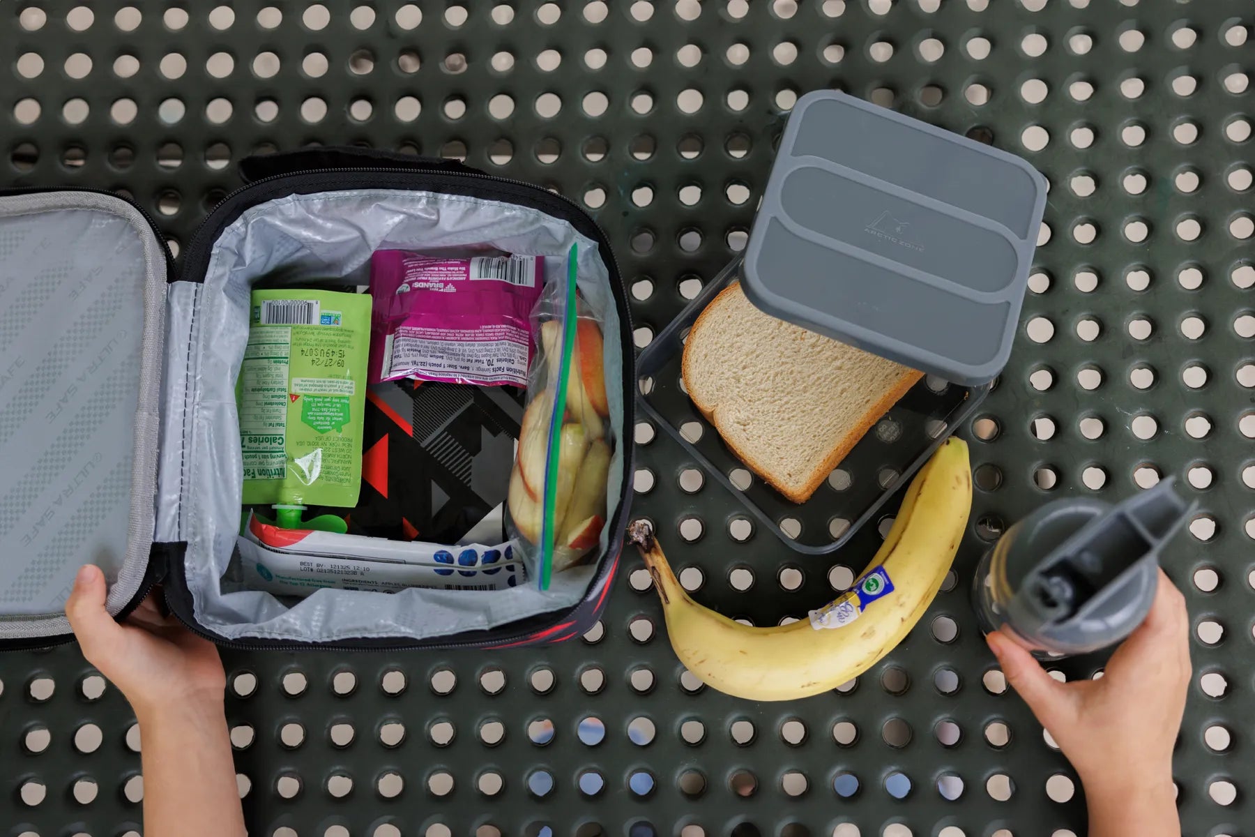 Arcitc Zone lunch bag filled with snacks on a picnic table