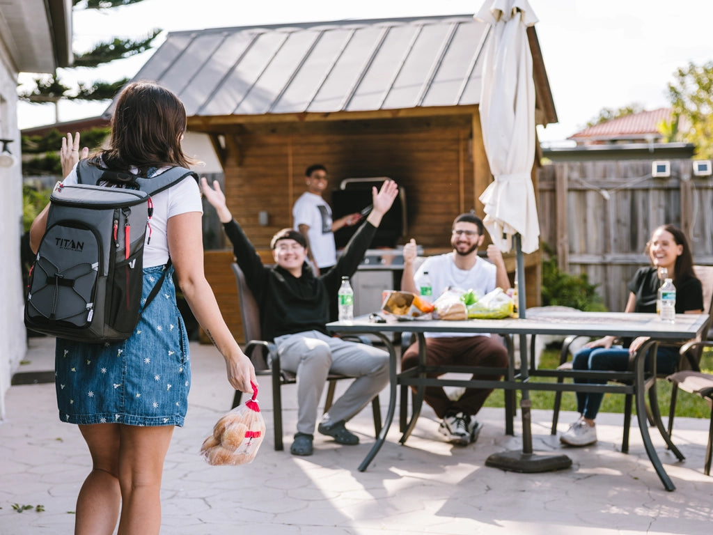 Girl wearing a Titan Eco 24 Can Backpack Cooler arriving to a backyard party