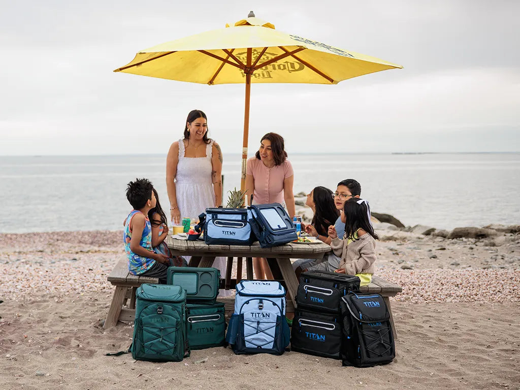 Family at a picnic table at the beach with Titan Coolers