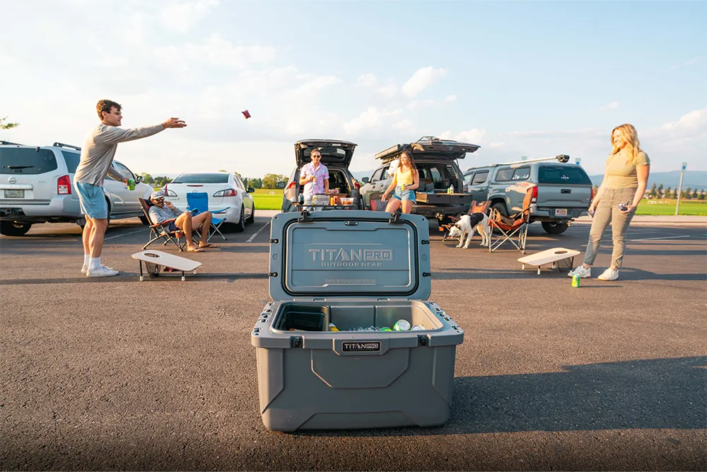 Group of friends playing cornhole at a tailgating party.