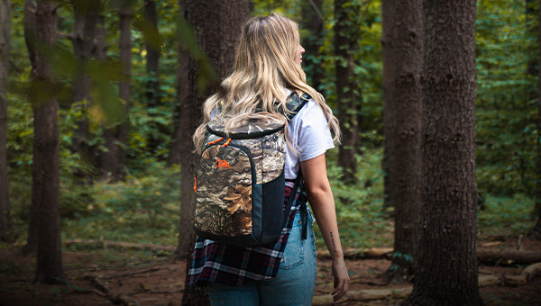 Person wearing an Arctic Zone Realtree Camo Backpack Cooler in a forest