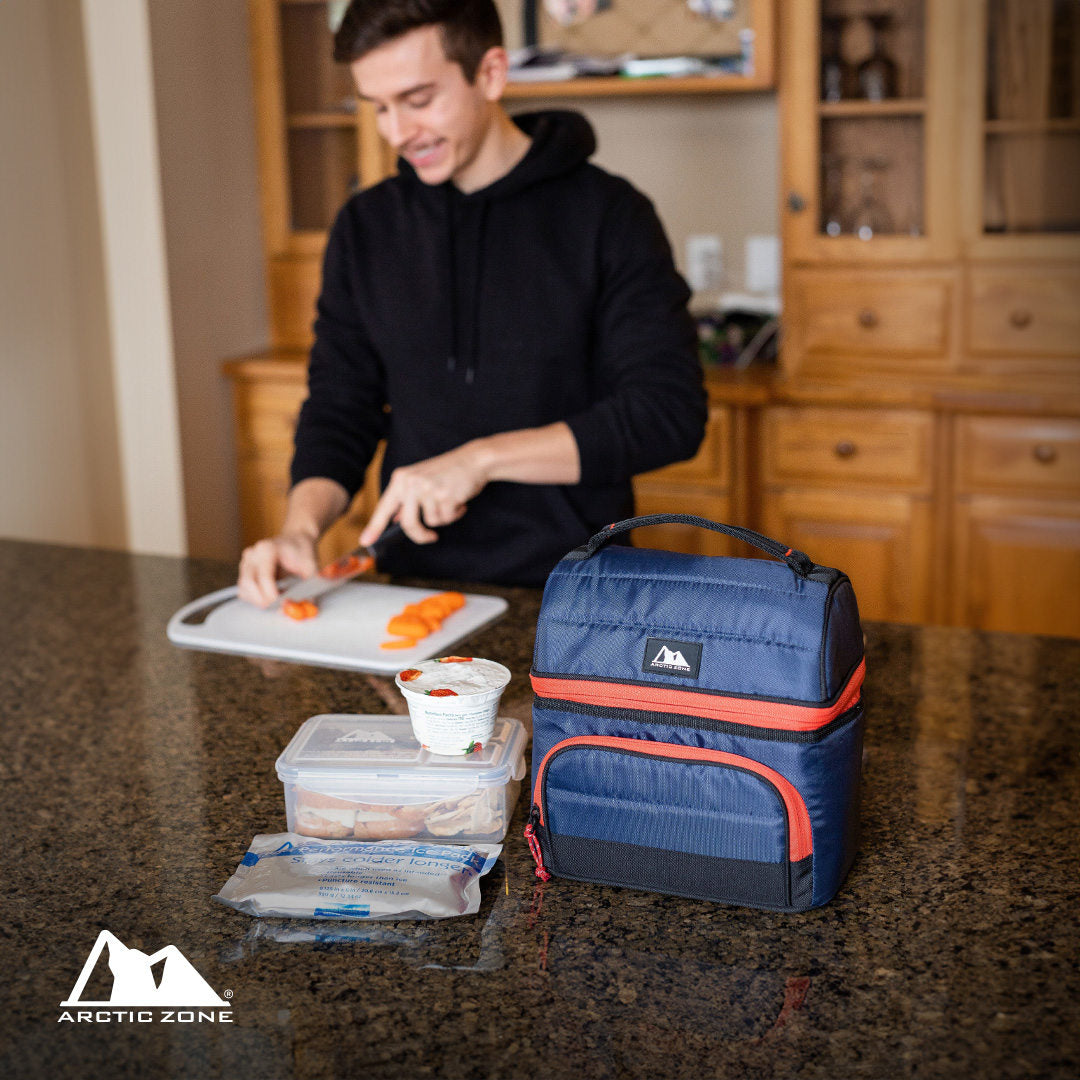 Guy meal prepping in the kitchen with an Arctic Zone lunch bag on the counter