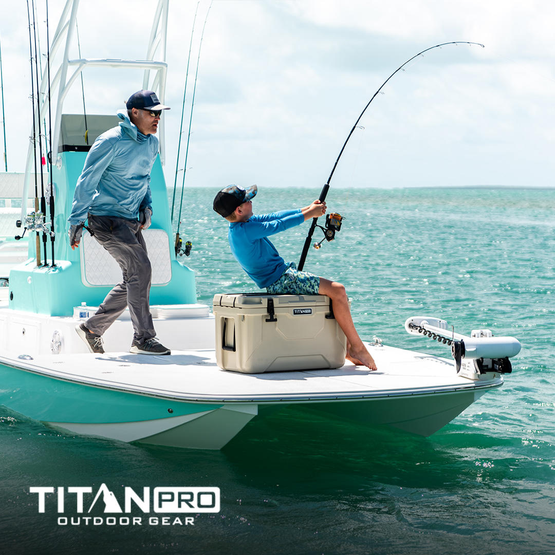 Father and son with a Titan PRO hard cooler on a boat fishing